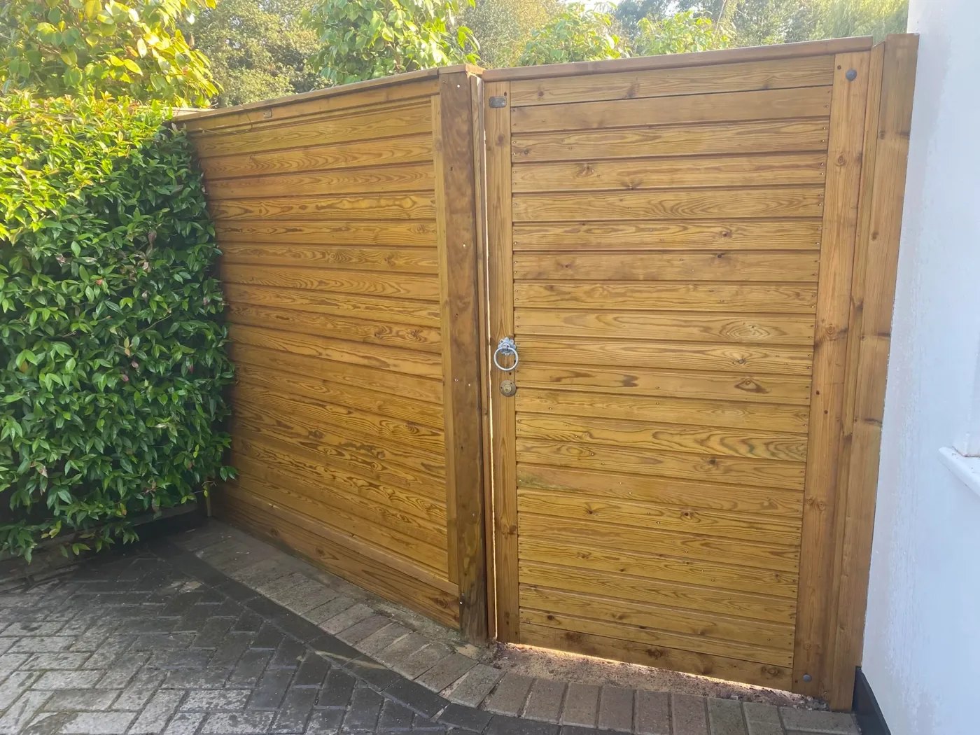 Bespoke hardwood driveway gates between brick piers
