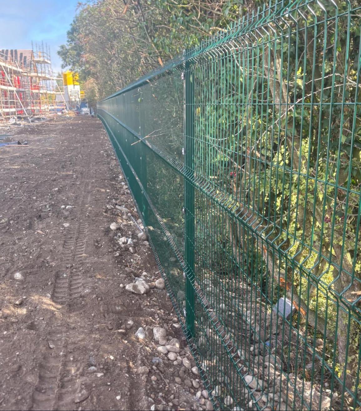 Green mesh security fencing installed along a commercial boundary